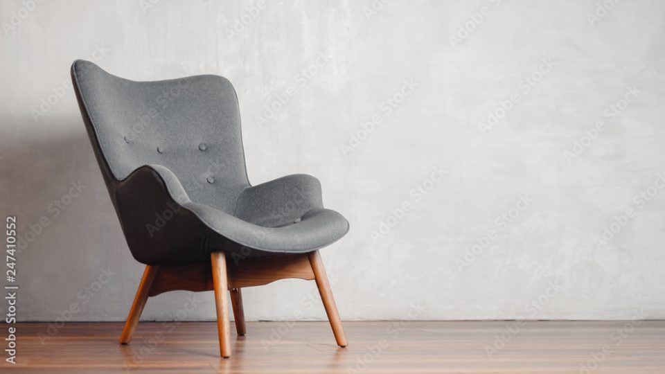 Gray chair in white concrete room for copy space. Concept of minimalism