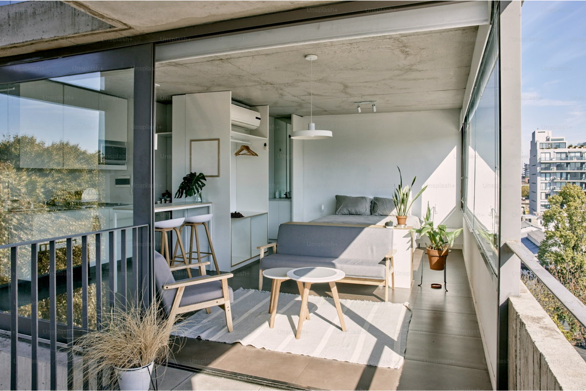 a balcony with a couch, table and chairs at The Stinger