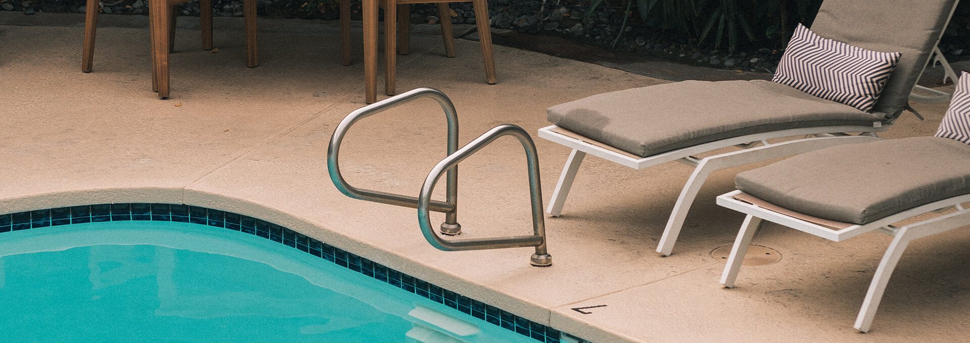 a patio area with chairs, tables, and a pool